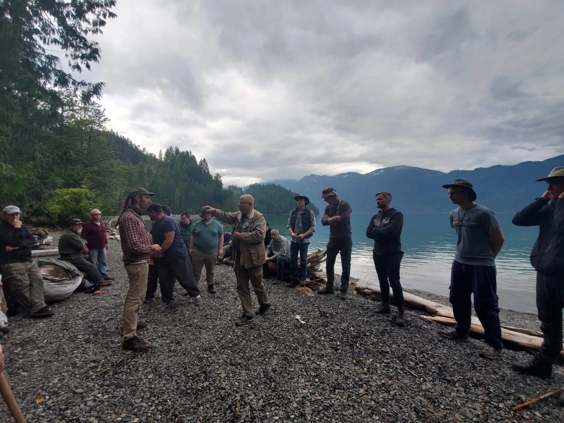The production men lined up on the shore, mountains behind