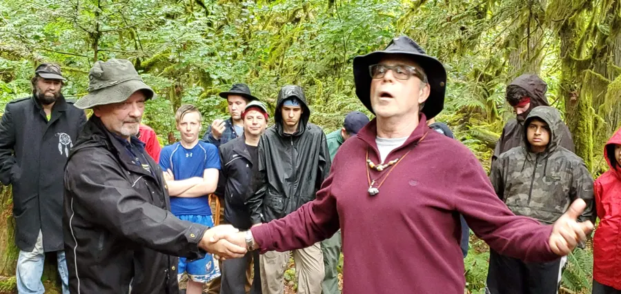 men in the forest circle arms out, 2019