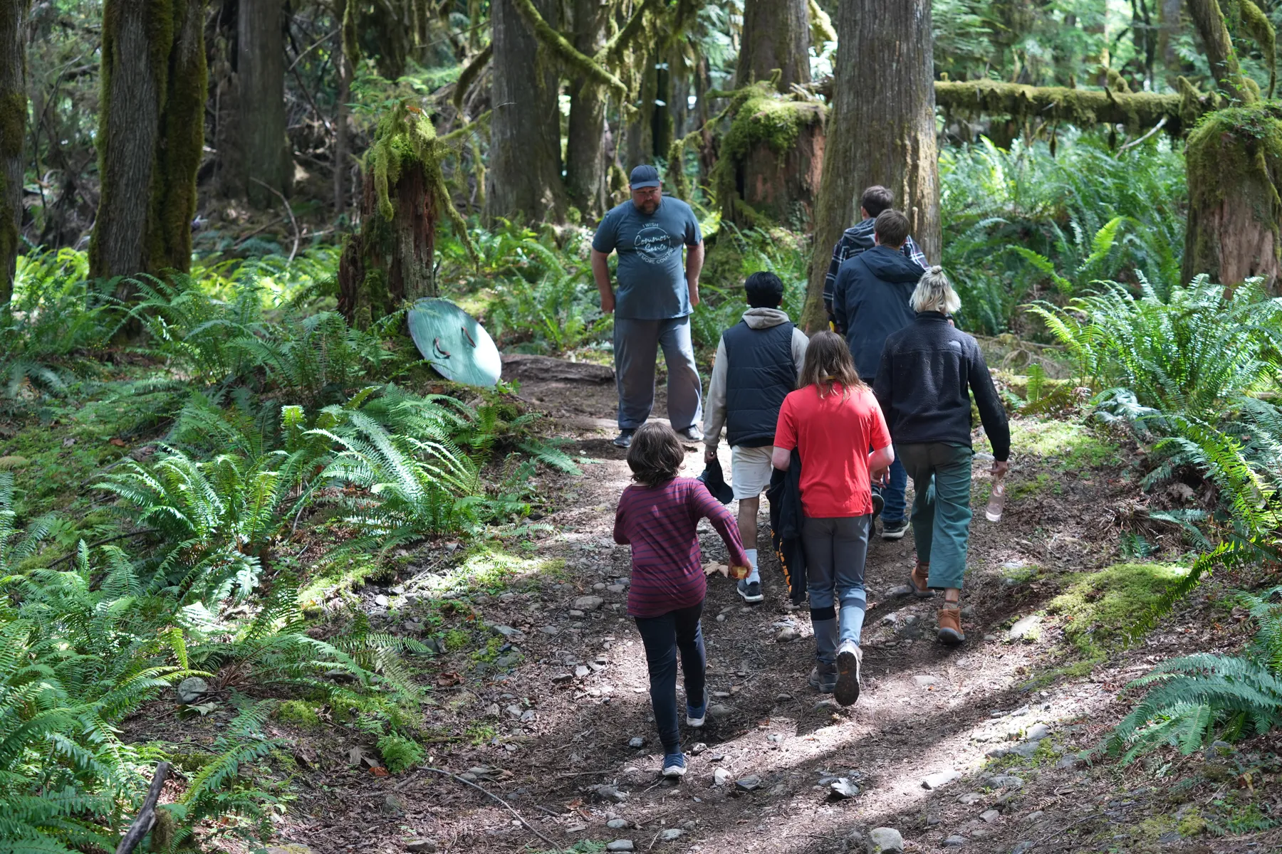Young men walking single file into the old growth