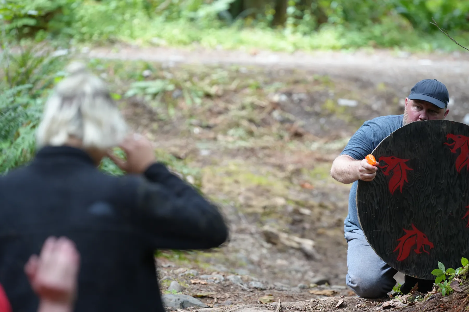 Young men with wooden shields in the forest quest