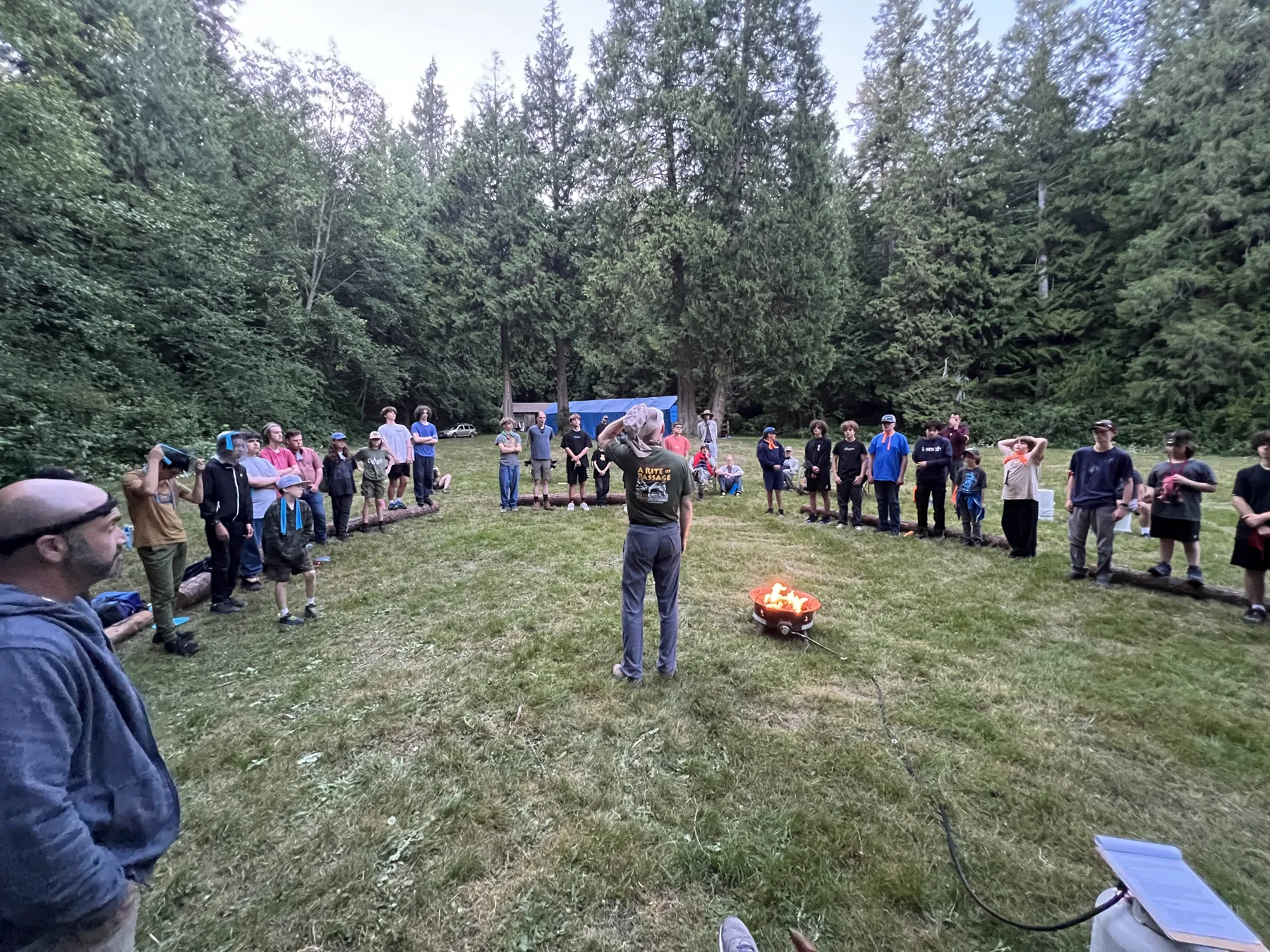 The whole weekend in one circle in the meadow at dusk, a fire in the middle